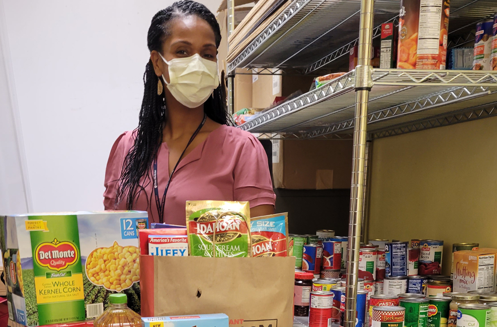Dietitian Zena Harrison stands with food collected for a 2021 holiday giveaway at HUP Cedar.